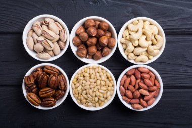 Fındık karışımı: antep fıstığı, badem, ceviz, çam fıstığı, fındık ve kaju. Kase backgrond içinde snack