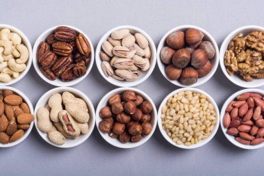 Fındık karışımı: antep fıstığı, badem, ceviz, çam fıstığı, fındık ve kaju. Kase backgrond içinde snack