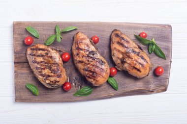 Izgara tavuk göğsü (fileto) fesleğen ve domates ile. Barbekü arka plan