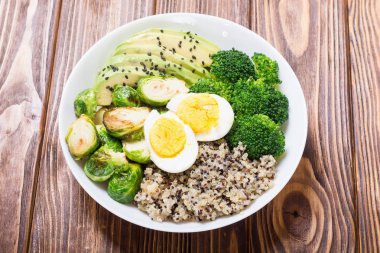 Quinoa, yumurta, avokado, Brüksel lahanası ve brokoli ile Buda kase. Ahşap backggroun yiyecek vegan salataya