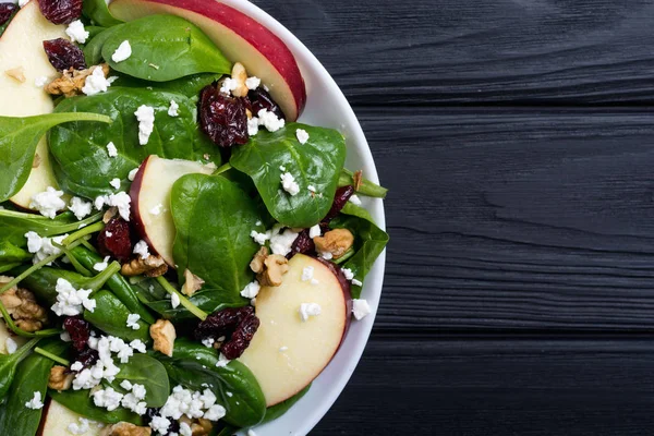Elma, peynir, ceviz ve kurutulmuş kızılcık sonbahar ıspanak salatası. Sağlıklı vejetaryen yemek