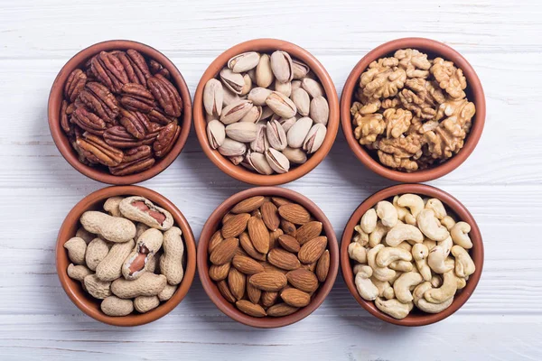 Fındık karışımı: antep fıstığı, badem, ceviz, çam fıstığı, fındık ve kaju. Kase backgrond içinde snack