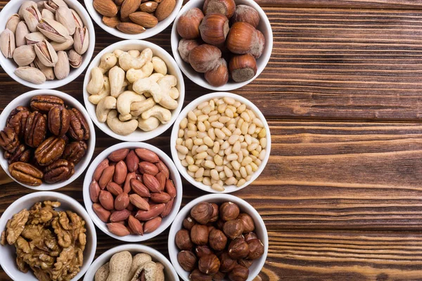 Fındık karışımı: antep fıstığı, badem, ceviz, çam fıstığı, fındık ve kaju. Kase backgrond içinde snack