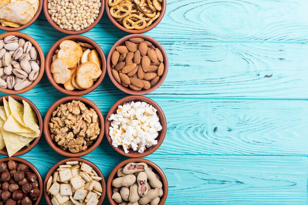 Смесь закусок: крендельки, крекеры, чипсы, орехи и начос
