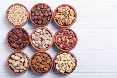 Fındık karışımı: antep fıstığı, badem, ceviz, çam fıstığı, fındık ve kaju. Kase backgrond içinde snack