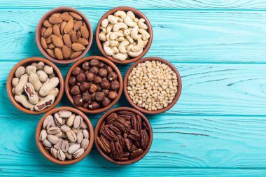 Fındık karışımı: antep fıstığı, badem, ceviz, çam fıstığı, fındık ve kaju. Kase backgrond içinde snack