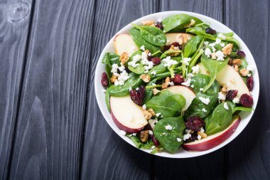 Elma, peynir, ceviz ve kurutulmuş kızılcık sonbahar ıspanak salatası. Sağlıklı vejetaryen yemek