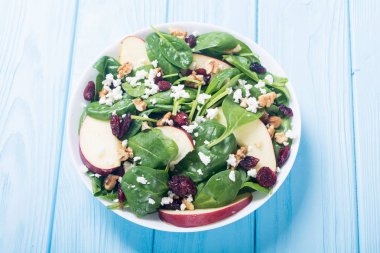 Elma, peynir, ceviz ve kurutulmuş kızılcık sonbahar ıspanak salatası. Sağlıklı vejetaryen yemek