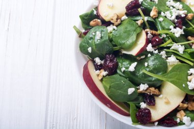 Elma, peynir, ceviz ve kurutulmuş kızılcık sonbahar ıspanak salatası. Sağlıklı vejetaryen yemek