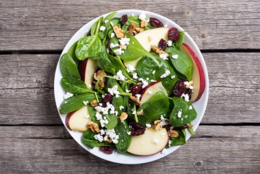 Elma, peynir, ceviz ve kurutulmuş kızılcık sonbahar ıspanak salatası. Sağlıklı vejetaryen yemek