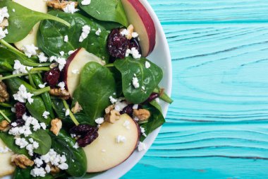 Elma, peynir, ceviz ve kurutulmuş kızılcık sonbahar ıspanak salatası. Sağlıklı vejetaryen yemek