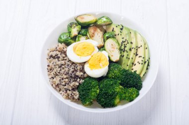 Quinoa, yumurta, avokado, Brüksel lahanası ve brokoli ile Buda kase. Ahşap backggroun yiyecek vegan salataya