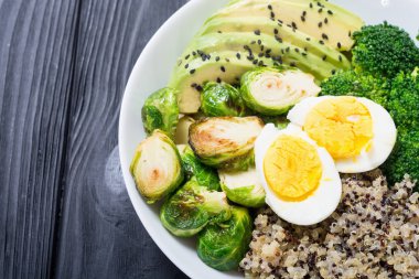 Quinoa, yumurta, avokado, Brüksel lahanası ve brokoli ile Buda kase. Ahşap backggroun yiyecek vegan salataya