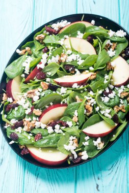 Elma, peynir, ceviz ve kurutulmuş kızılcık sonbahar ıspanak salatası. Sağlıklı vejetaryen yemek