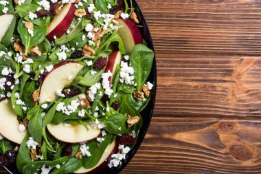 Elma, peynir, ceviz ve kurutulmuş kızılcık sonbahar ıspanak salatası. Sağlıklı vejetaryen yemek