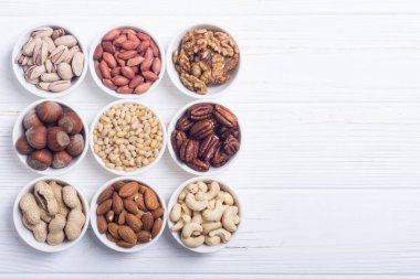 Fındık karışımı: antep fıstığı, badem, ceviz, çam fıstığı, fındık ve kaju. Kase backgrond içinde snack