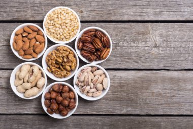 Fındık karışımı: antep fıstığı, badem, ceviz, çam fıstığı, fındık ve kaju. Kase backgrond içinde snack