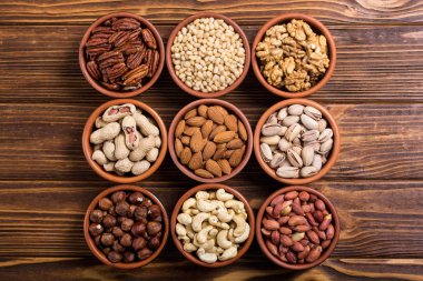 Fındık karışımı: antep fıstığı, badem, ceviz, çam fıstığı, fındık ve kaju. Kase backgrond içinde snack