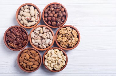 Fındık karışımı: antep fıstığı, badem, ceviz, çam fıstığı, fındık ve kaju. Kase backgrond içinde snack