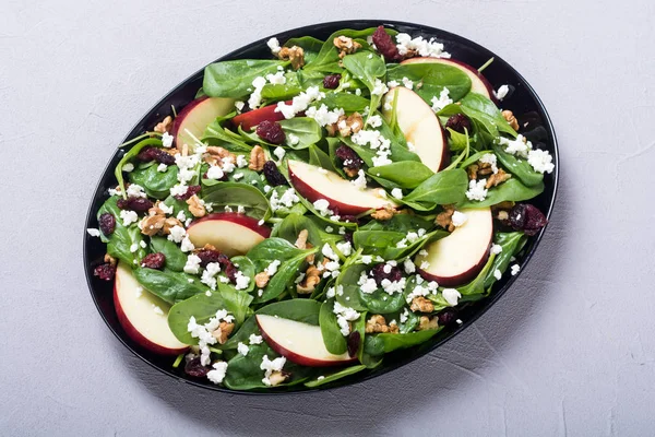 Elma, peynir, ceviz ve kurutulmuş kızılcık sonbahar ıspanak salatası. Sağlıklı vejetaryen yemek