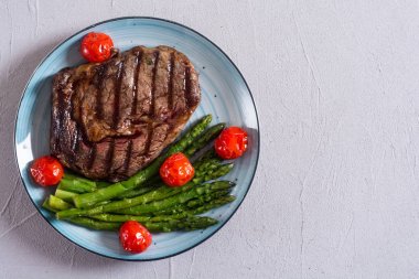 Kiraz domates ve kuşkonmaz ile ızgara sığır biftek ribeye