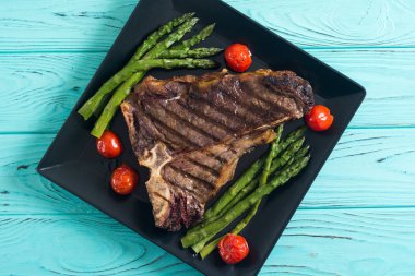Kuşkonmaz ve kiraz domates ile ızgara T-kemik biftek 