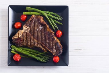 Kuşkonmaz ve kiraz domates ile ızgara T-kemik biftek 