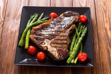 Kuşkonmaz ve kiraz domates ile ızgara T-kemik biftek 