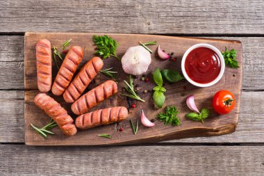 Otlar, baharatlar ve ketçap ile kızarmış sosis