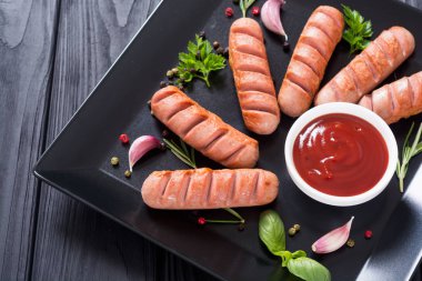 Otlar, baharatlar ve ketçap ile kızarmış sosis