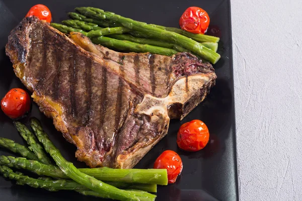 Kuşkonmaz ve kiraz domates ile ızgara T-kemik biftek 