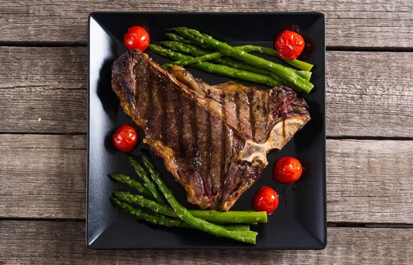 Kuşkonmaz ve kiraz domates ile ızgara T-kemik biftek 