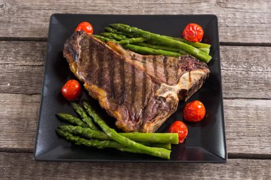 Kuşkonmaz ve kiraz domates ile ızgara T-kemik biftek 