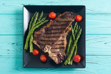 Kuşkonmaz ve kiraz domates ile ızgara T-kemik biftek 