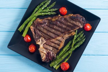 Kuşkonmaz ve kiraz domates ile ızgara T-kemik biftek 