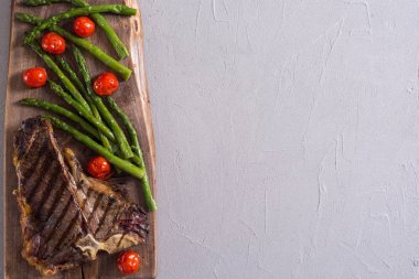 Kuşkonmaz ve kiraz domates ile ızgara T-kemik biftek 