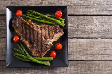 Kuşkonmaz ve kiraz domates ile ızgara T-kemik biftek 