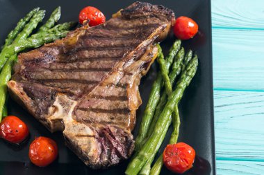 Kuşkonmaz ve kiraz domates ile ızgara T-kemik biftek 