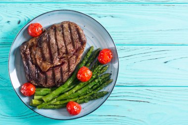 Kiraz domates ve kuşkonmaz ile ızgara sığır biftek ribeye