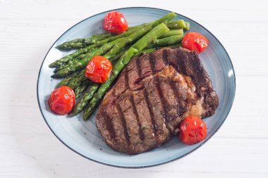 Kiraz domates ve kuşkonmaz ile ızgara sığır biftek ribeye
