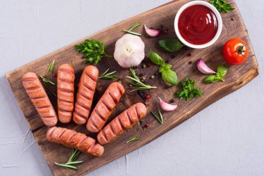 Otlar, baharatlar ve ketçap ile kızarmış sosis