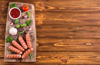 Otlar, baharatlar ve ketçap ile kızarmış sosis