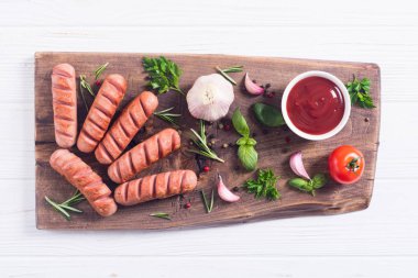 Otlar, baharatlar ve ketçap ile kızarmış sosis