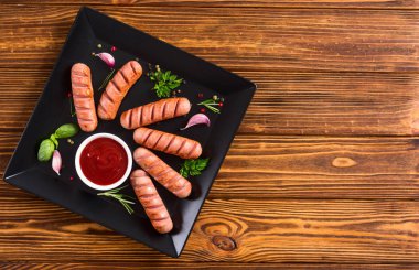 Otlar, baharatlar ve ketçap ile kızarmış sosis