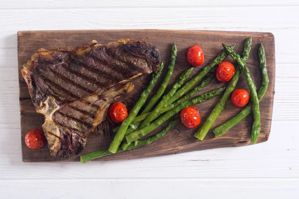 Grilled T-bone steak with asparagus and cherry tomatoes — Stock Photo, Image