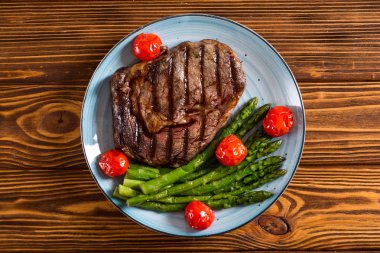 Kiraz domates ve kuşkonmaz ile ızgara sığır biftek ribeye