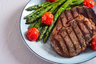 Kiraz domates ve kuşkonmaz ile ızgara sığır biftek ribeye