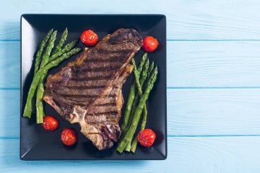 Kuşkonmaz ve kiraz domates ile ızgara T-kemik biftek 