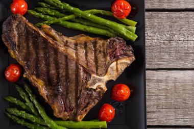 Kuşkonmaz ve kiraz domates ile ızgara T-kemik biftek 