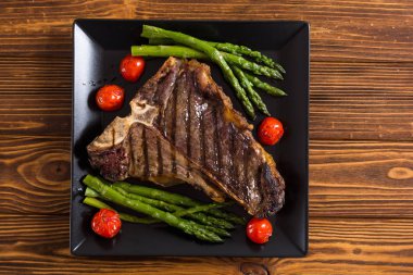 Kuşkonmaz ve kiraz domates ile ızgara T-kemik biftek 
